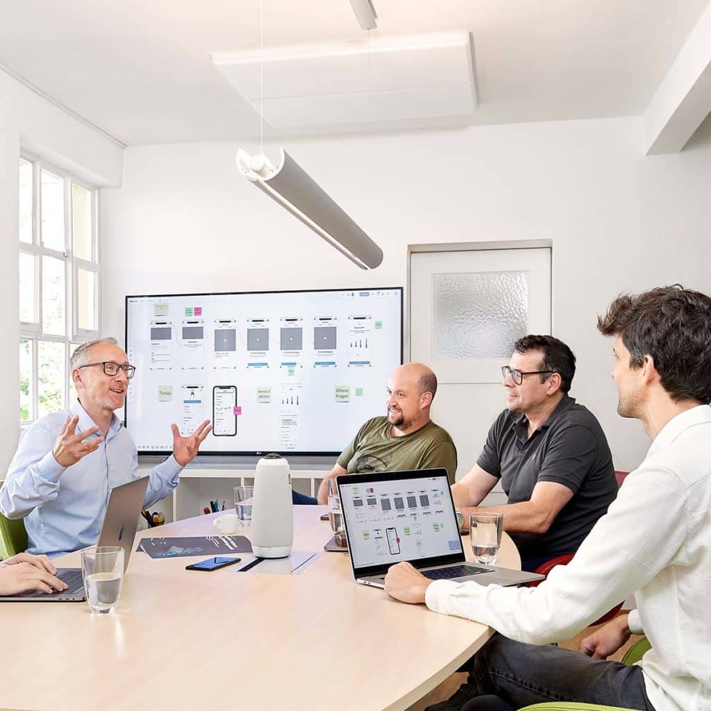 fluidmobile Meetingraum: Projektteam und Kunde bei einem Meeting zur Entwicklung eines mHealth-Produktes wie Medical App oder DiGA